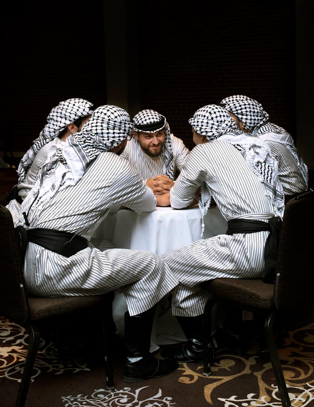 men with Arabian headdresses seated around a table